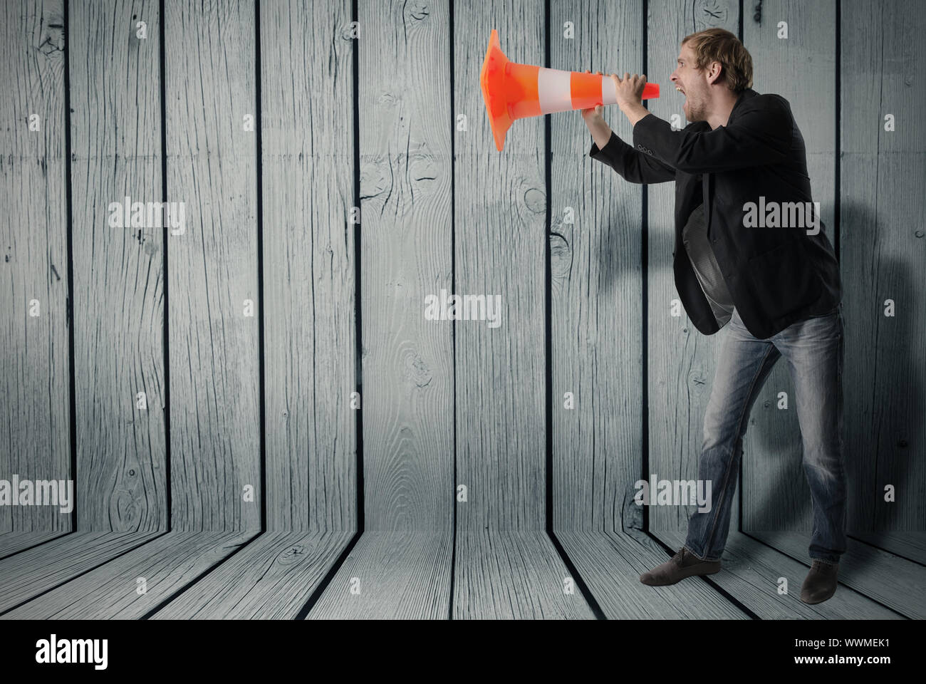 Man uses a warning cone as a megaphone Stock Photo