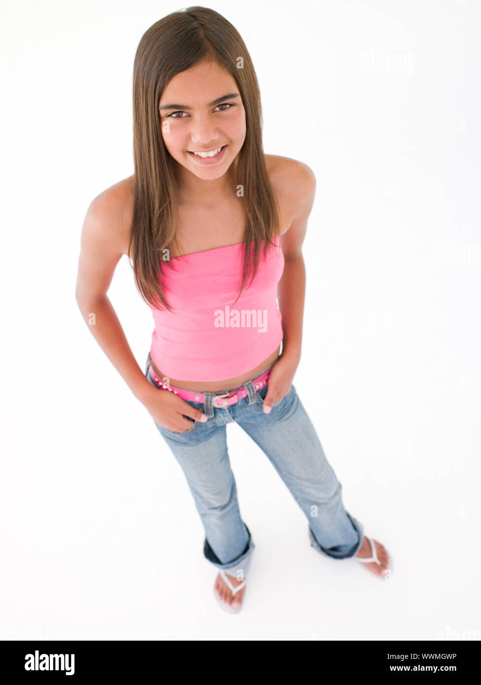 Young girl standing with hands on hips smiling Stock Photo - Alamy