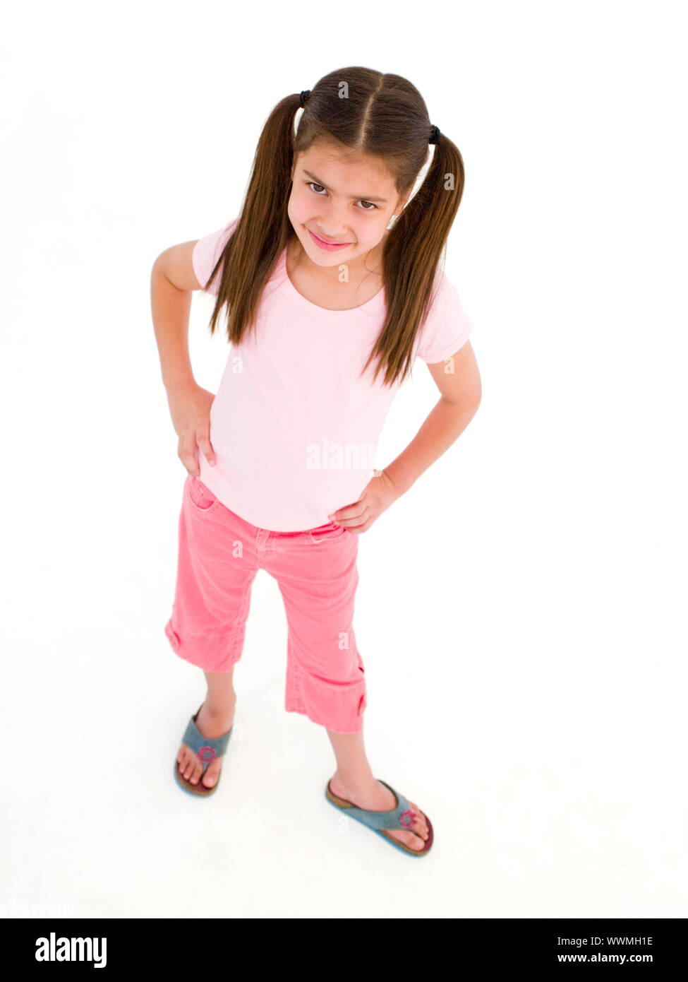 Young girl standing with hands on hips smiling Stock Photo - Alamy