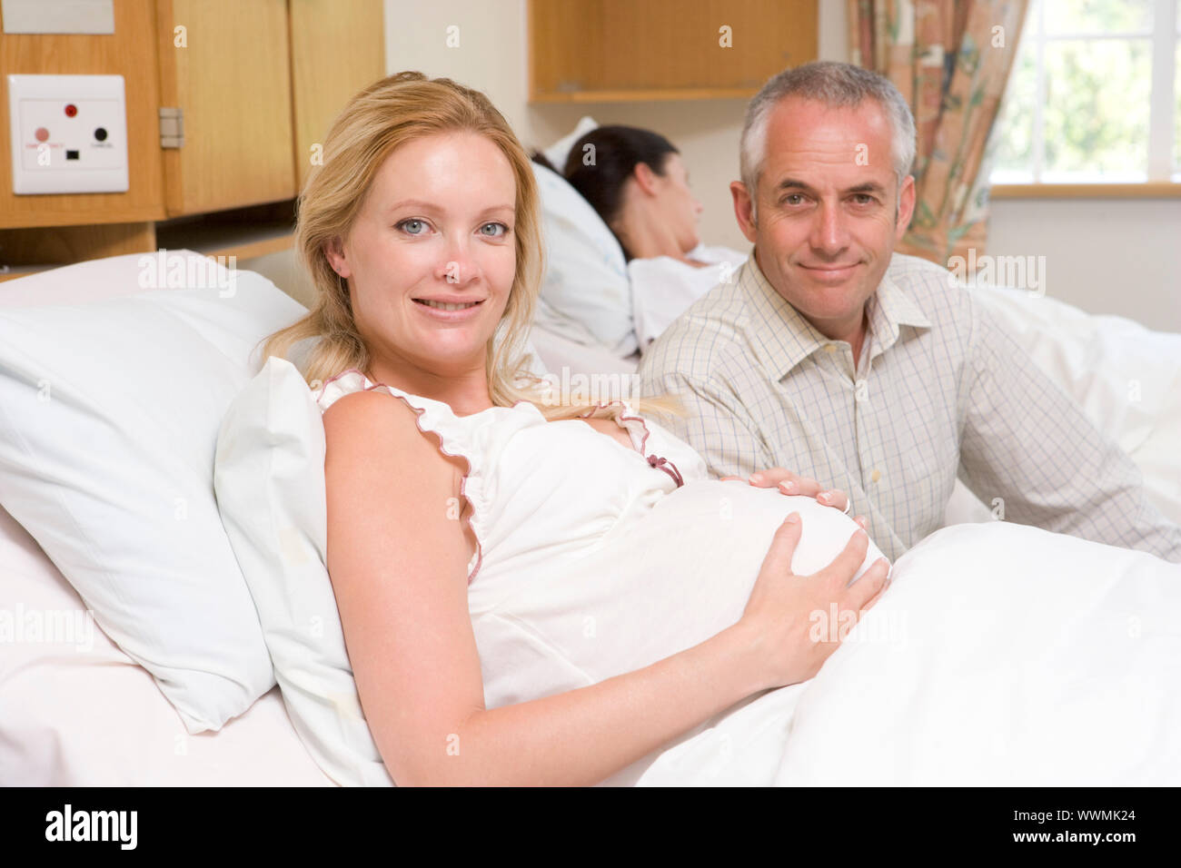 Pregnant woman with husband in hospital smiling Stock Photo Alamy