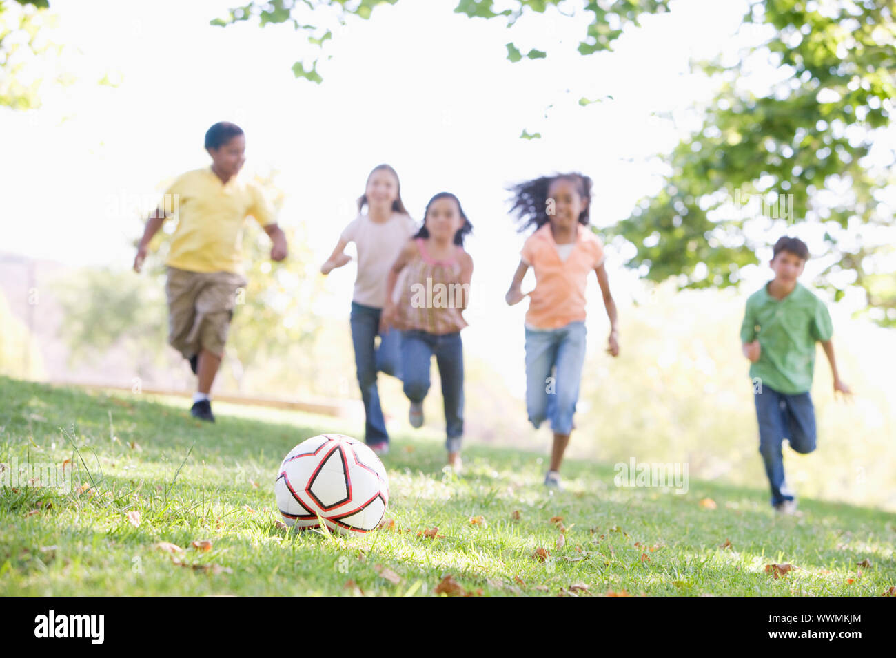 Five young friends playing soccer Stock Photo