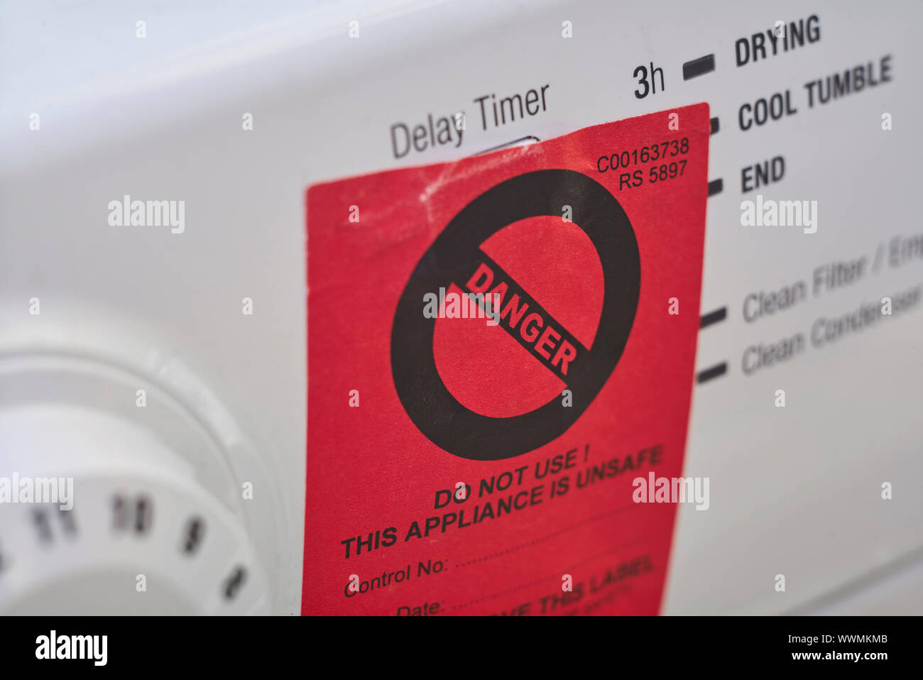 Red Danger label on a tumble dryer Stock Photo Alamy