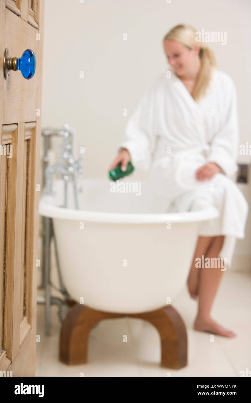 Woman in bathroom putting bubble bath in bathtub Stock Photo Alamy