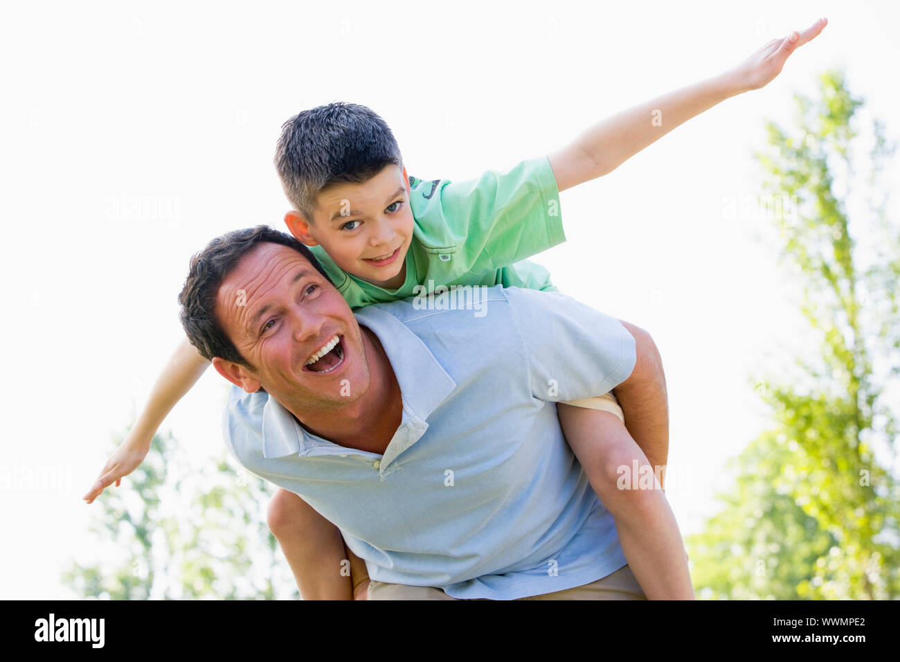 Man giving boy piggyback ride Man giving boy piggy back ride against white  background, model