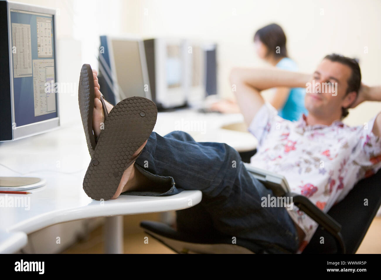 Man in computer room with feet up relaxing Stock Photo