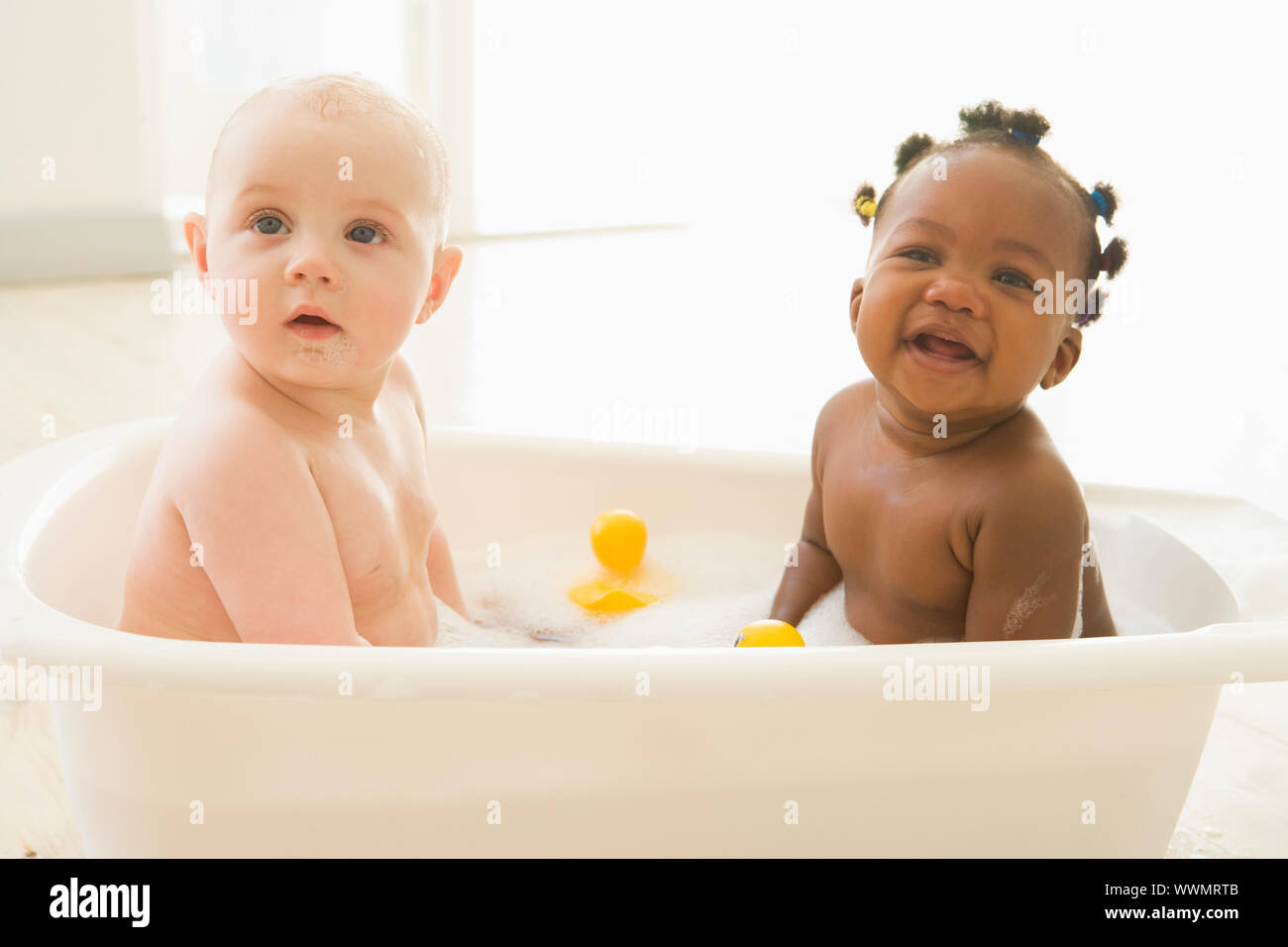 Two babies in bubble bath Stock Photo - Alamy