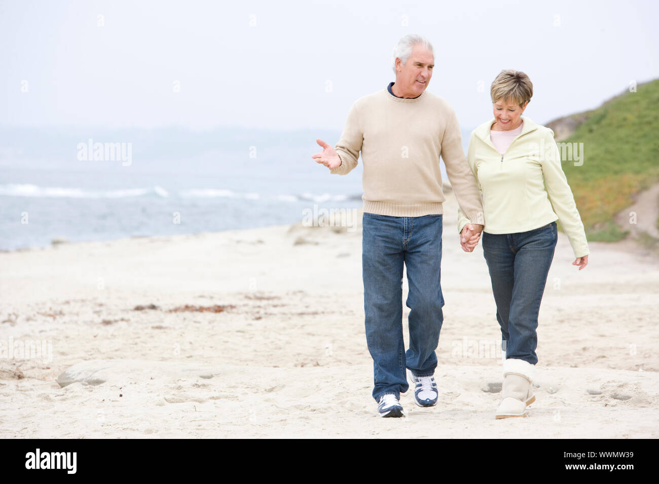 Couple at the beach holding hands and smiling Stock Photo - Alamy