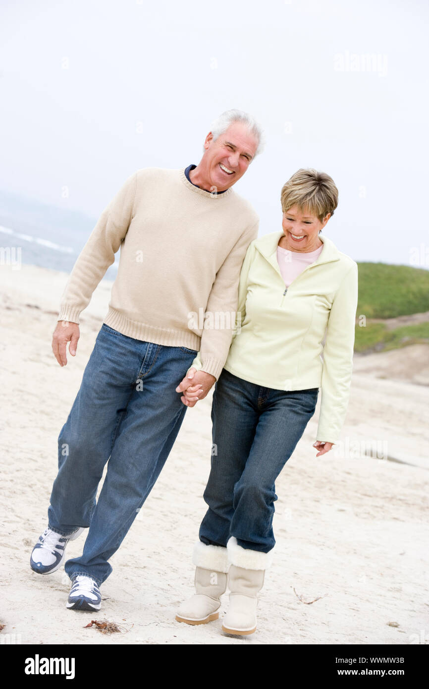 Couple at the beach holding hands and smiling Stock Photo - Alamy