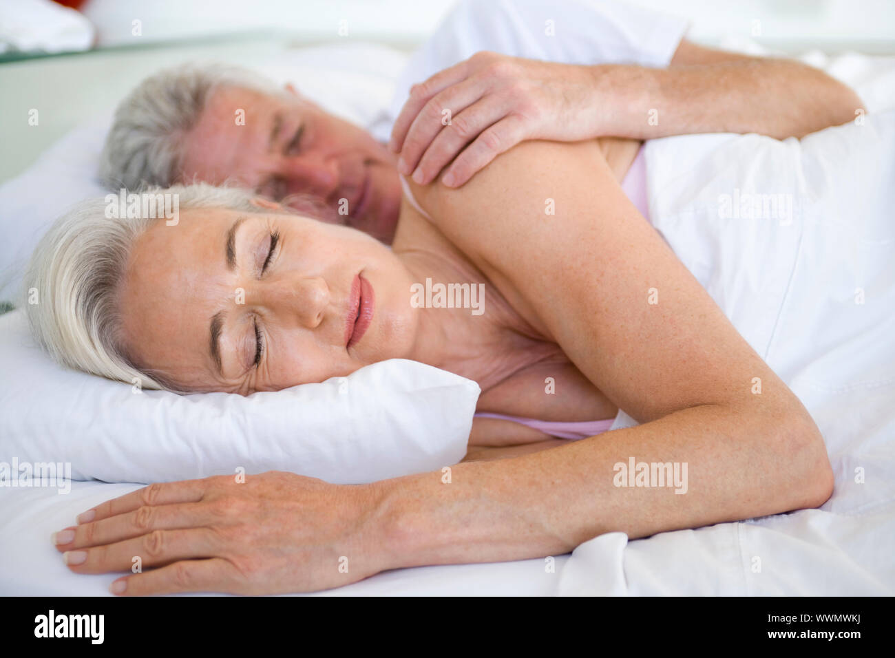 Couple lying in bed together sleeping Stock Photo