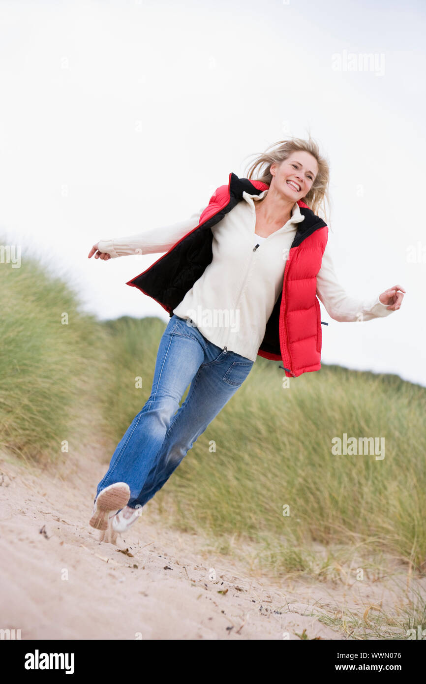 Woman running at beach smiling Stock Photo