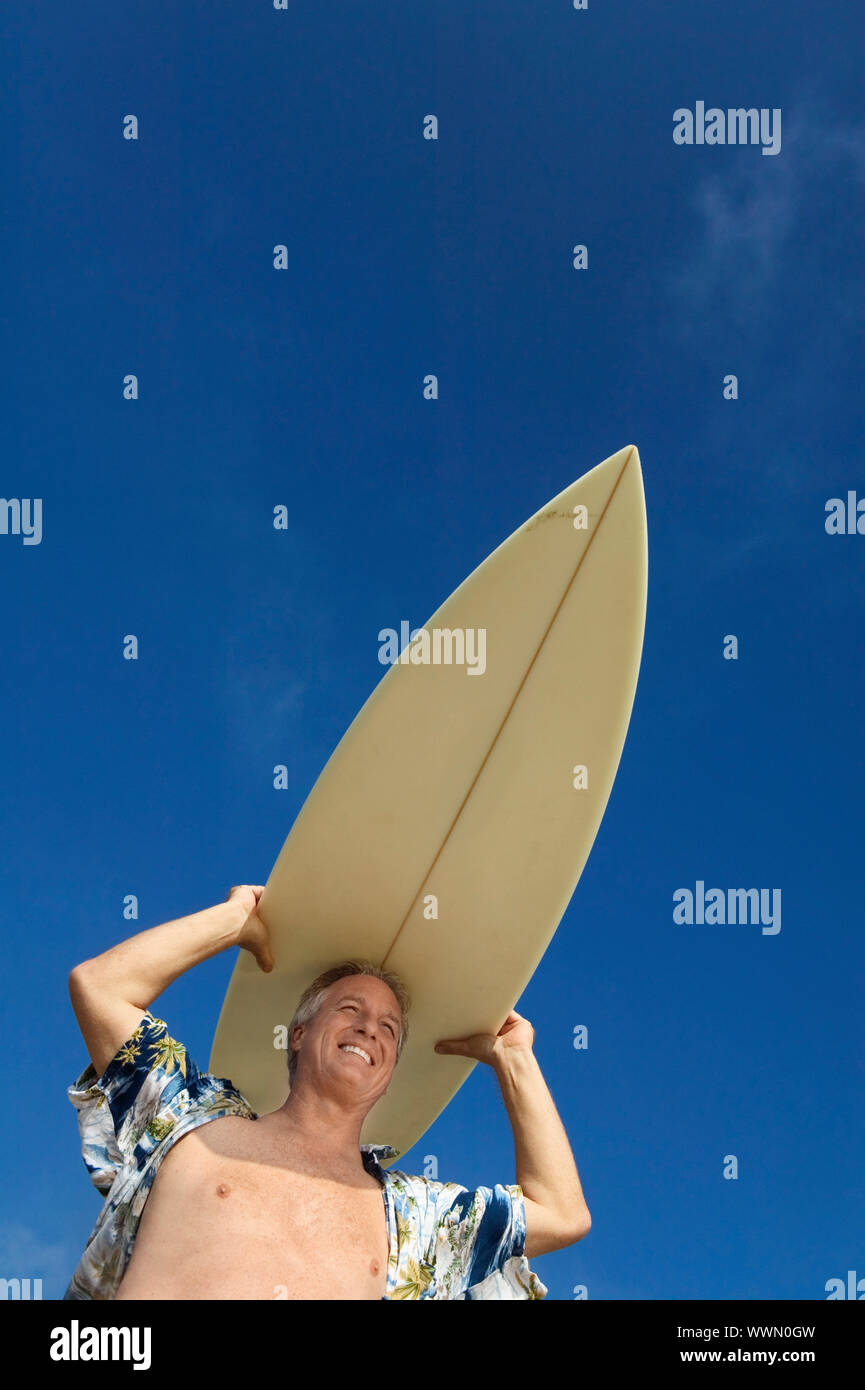MiddleAged Surfer Carrying Surfboard Stock Photo Alamy