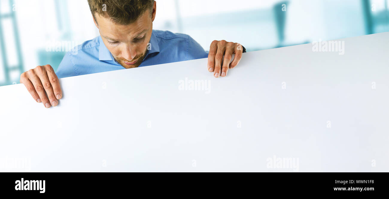 young man holding blank white banner with copy space Stock Photo