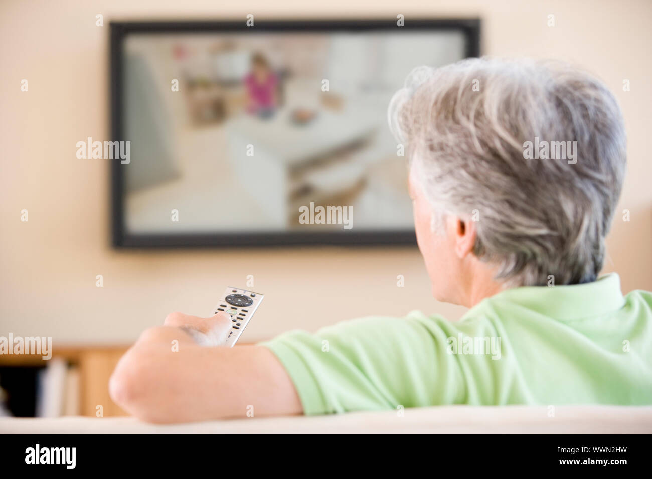 Man watching television using remote control Stock Photo - Alamy