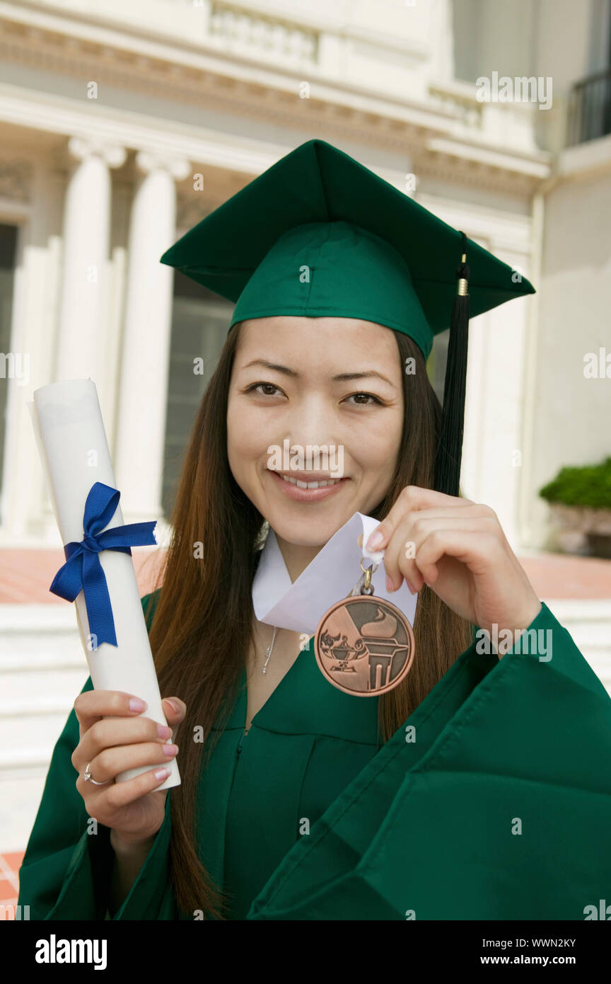 Graduate Holding Medal and Diploma Stock Photo