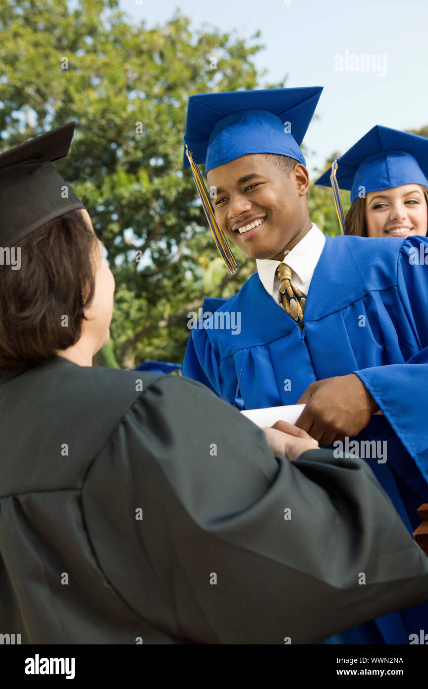 Graduate Shaking Hands and Receiving Diploma Stock Photo