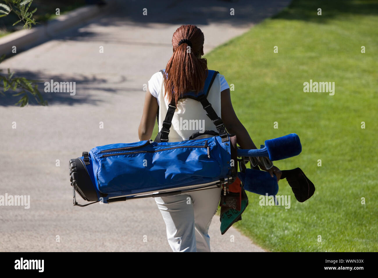 Woman Carrying Golf Club Bag Stock Photo - Alamy