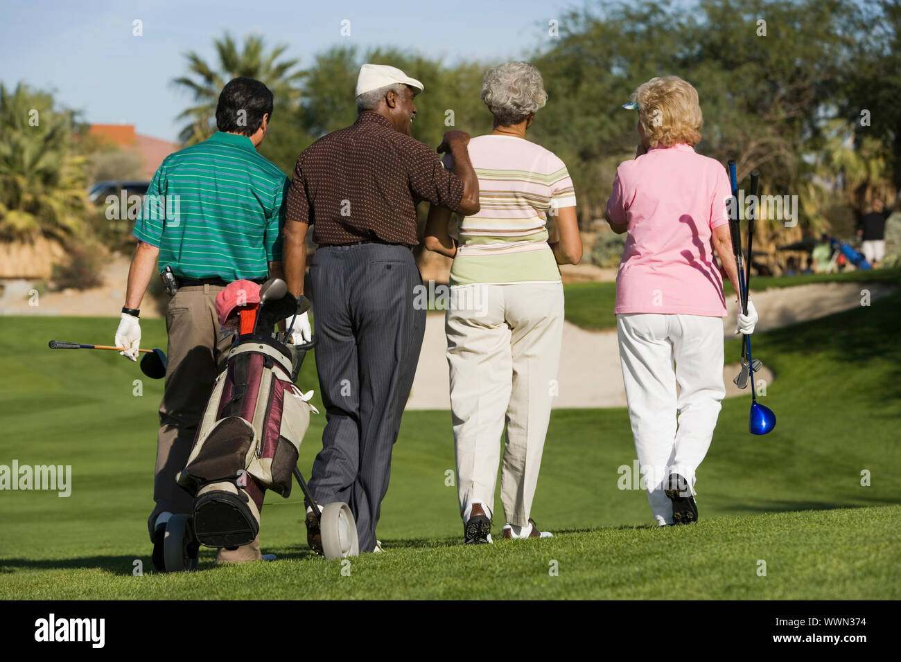 Friends Walking on Golf Course Stock Photo