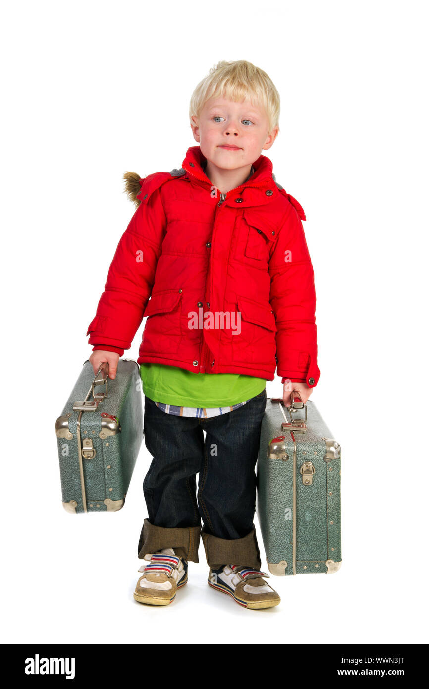 Little boy with suitcases and coat is walking away from home Stock