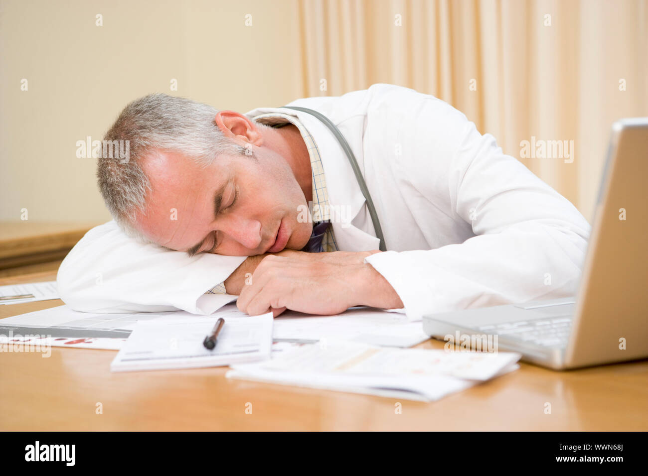 Doctor with laptop sleeping in doctor's office Stock Photo Alamy