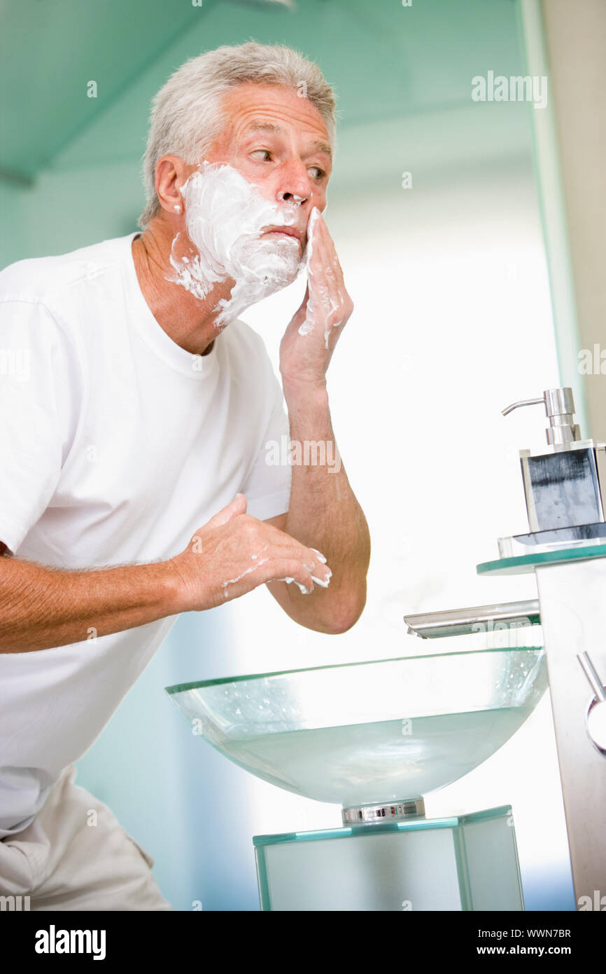 Man in bathroom shaving Stock Photo