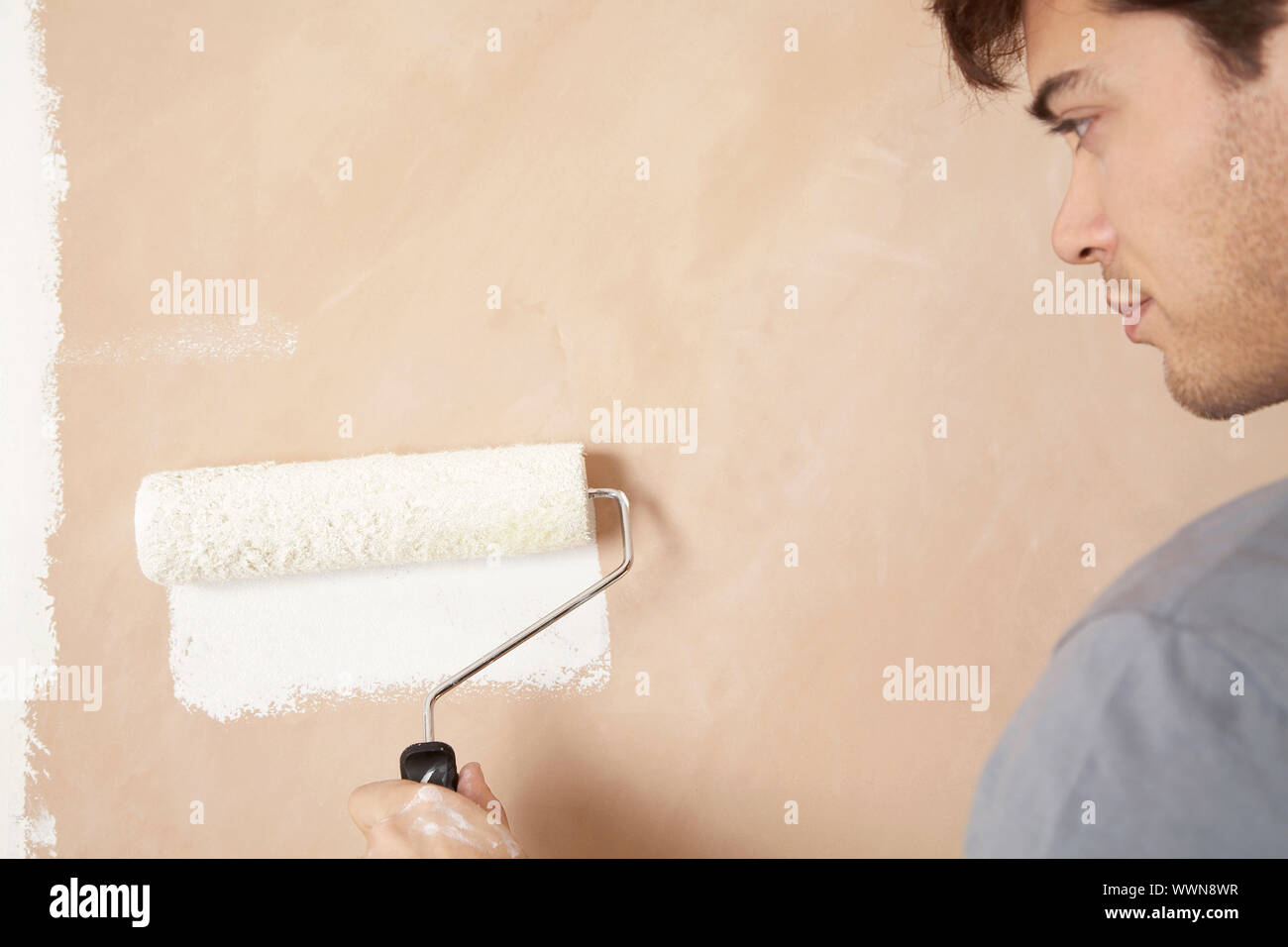 Man Painting Wall with Roller Stock Photo - Alamy