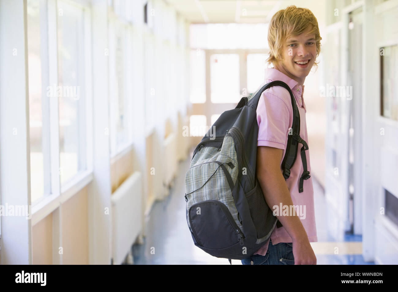 Male college student standing in university corridor Stock Photo - Alamy