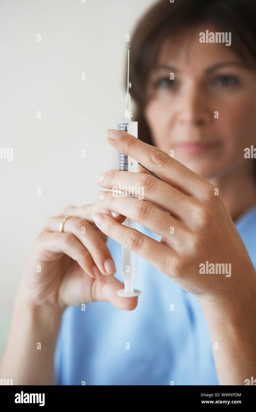 Nurse Preparing Needle For Injection Stock Photo