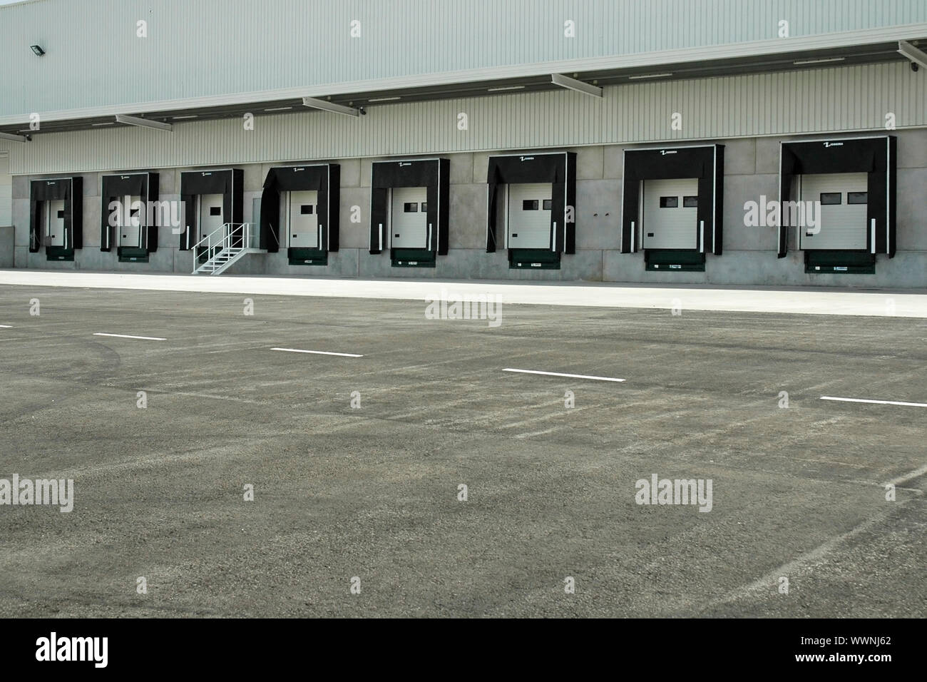 The loading area of a industrial warehouse with several loading bays and a truck. Stock Photo