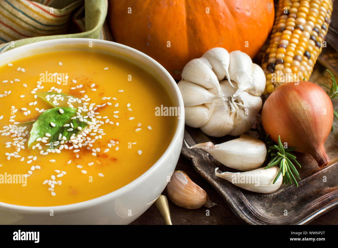 Fresh pumpkin soup with a spoon and vegetables on a wooden table Stock ...