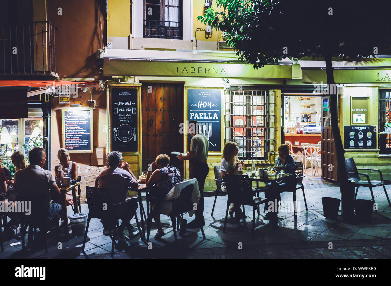 Seville, Spain - Sept 8, 2019: Tourists relaxing at terraces of traditional tapas bars at during in the historic centre of Seville, Andalusia, Spain Stock Photo