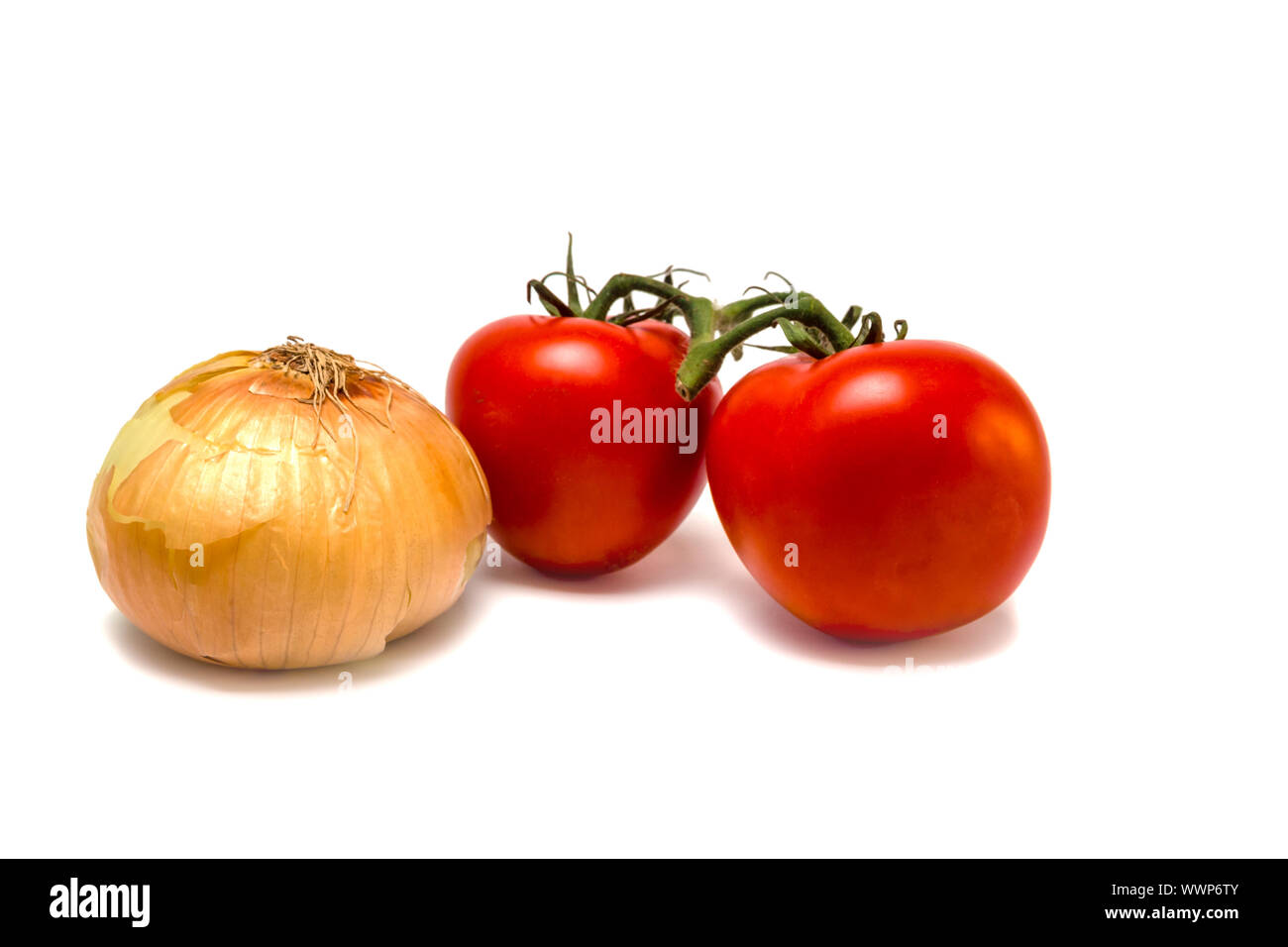 Two vine tomatoes and an onion isolated on white background. Selective focus. Stock Photo