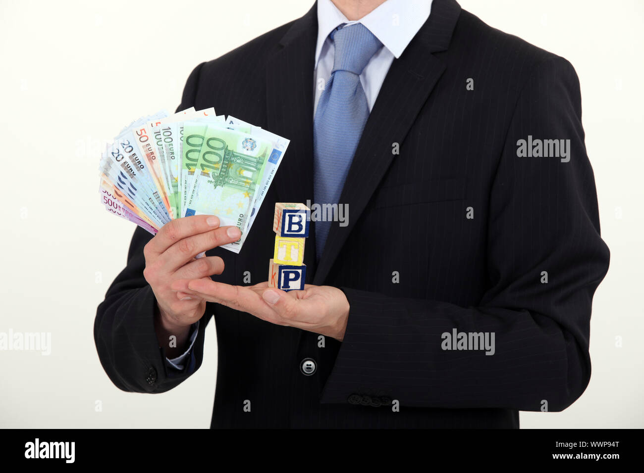 Man holding toy blocks and money Stock Photo