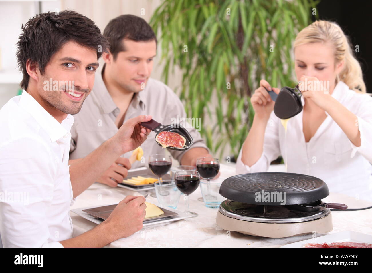 Friends eating raclette Stock Photo - Alamy
