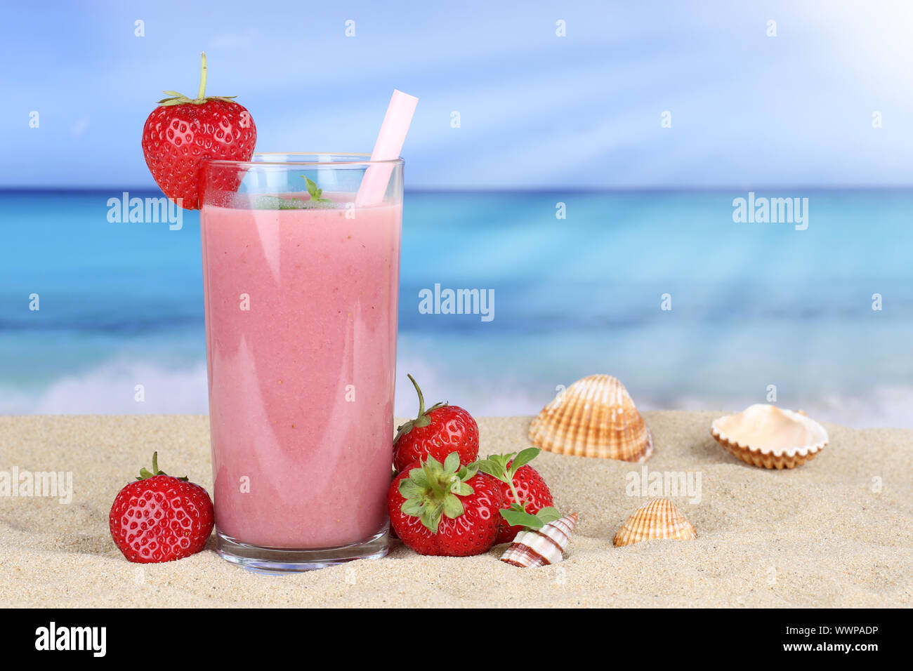 Strawberry smoothie juice with strawberries fruits fruit juice on the beach Stock Photo