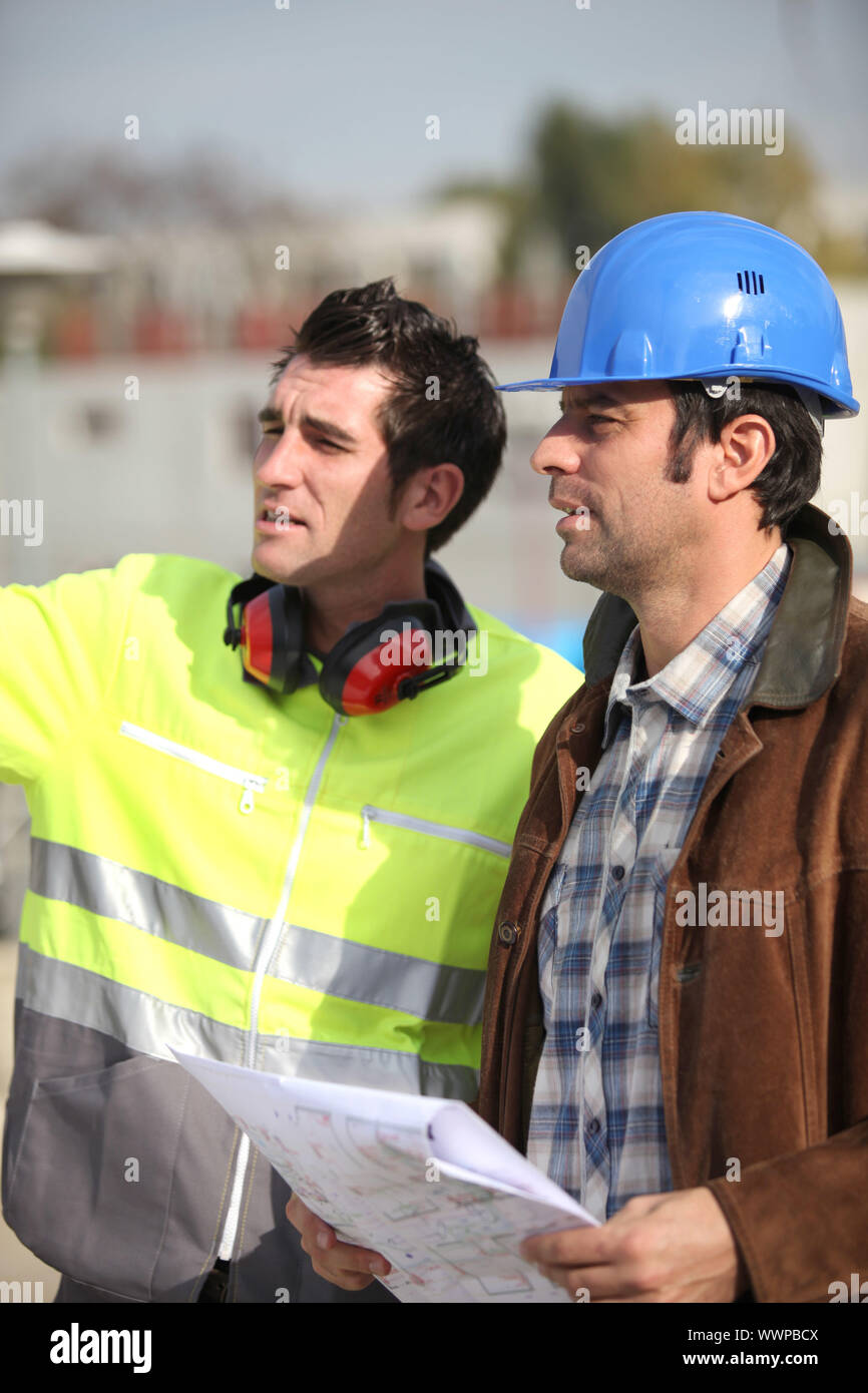 Architect and foreman looking at plans Stock Photo