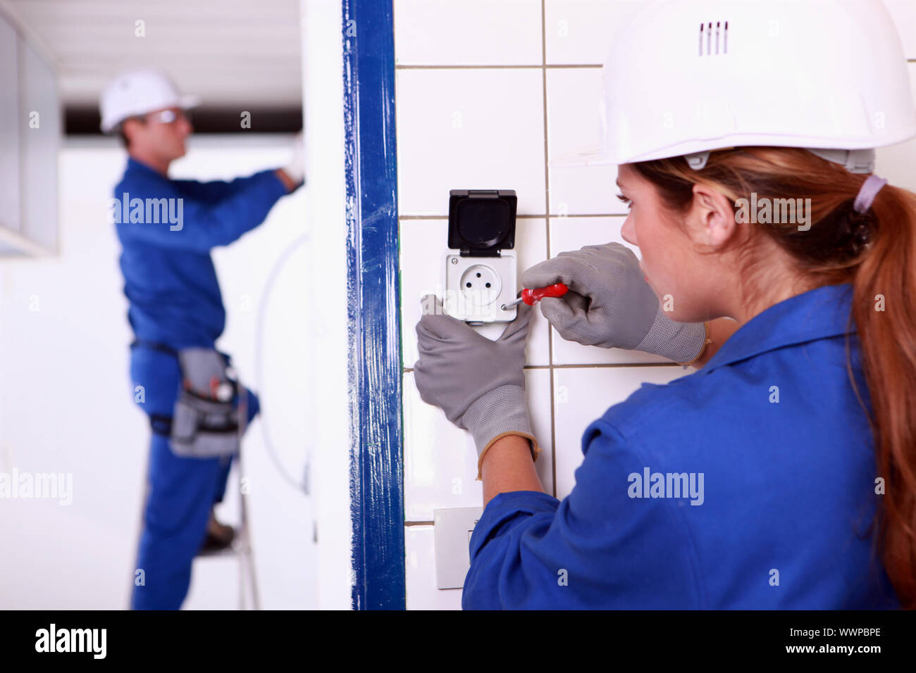 Female electrician installing a continental socket Stock Photo