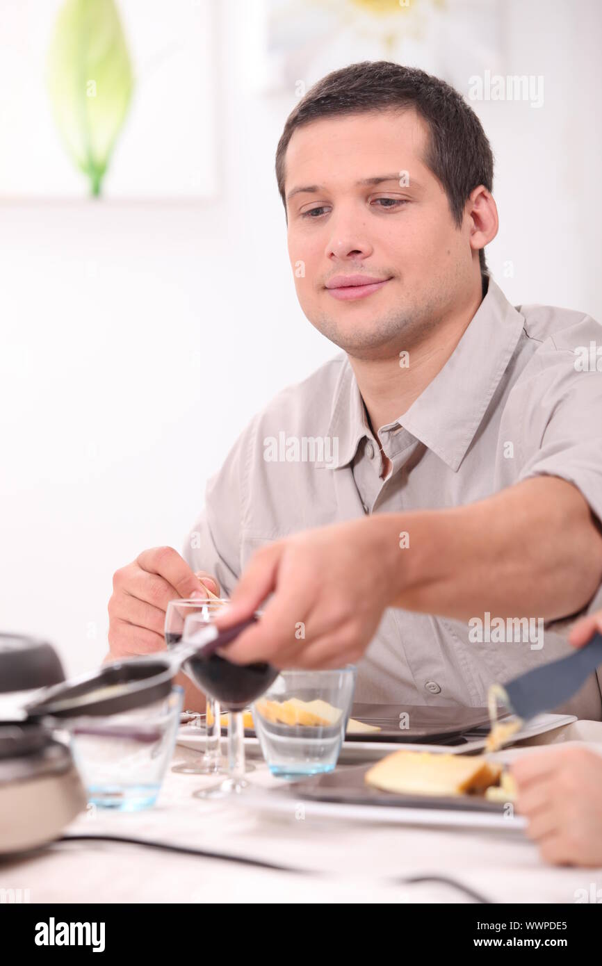 Man eating raclette Stock Photo - Alamy