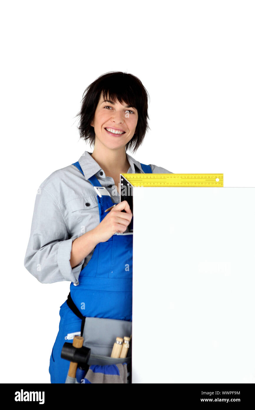 Female carpenter with a board left blank for your copy Stock Photo