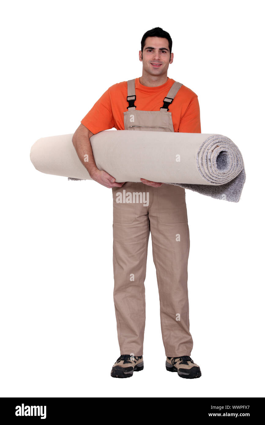 Carpet fitter carrying a roll of carpet Stock Photo