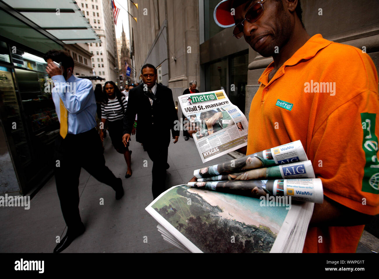 Trouble on Wall Street. A man hands out the Metro newspaper which has the headline 'Wall Street Massacre' on the front. The newspaper headline came after the start of the 2008 recession caused by failing housing market and subprime bundling scandal. Stock Photo