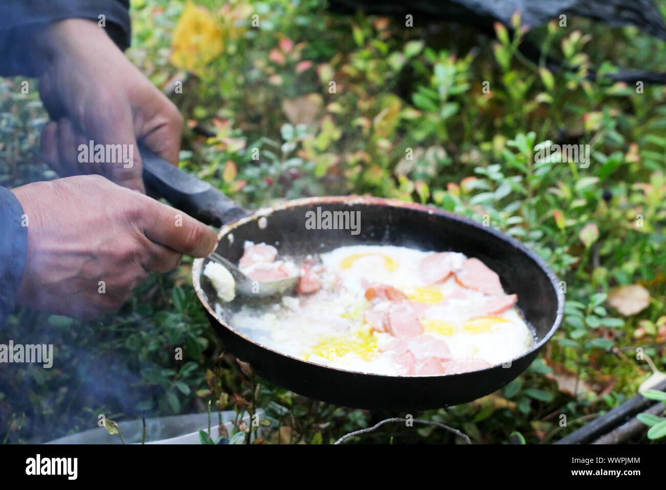 unusual way of cooking eggs on fire Stock Photo Alamy