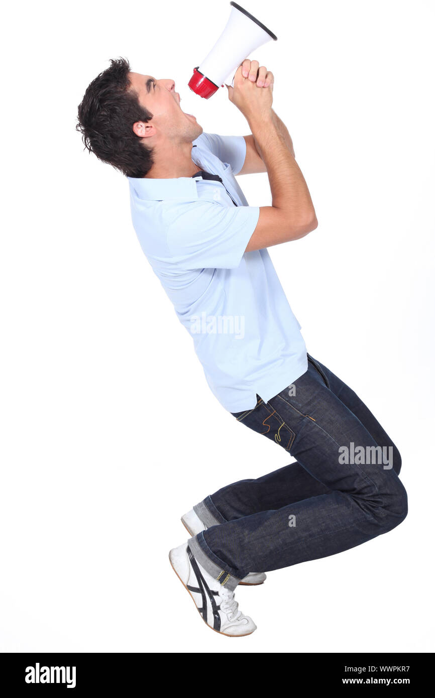 Young man shouting into a megaphone Stock Photo
