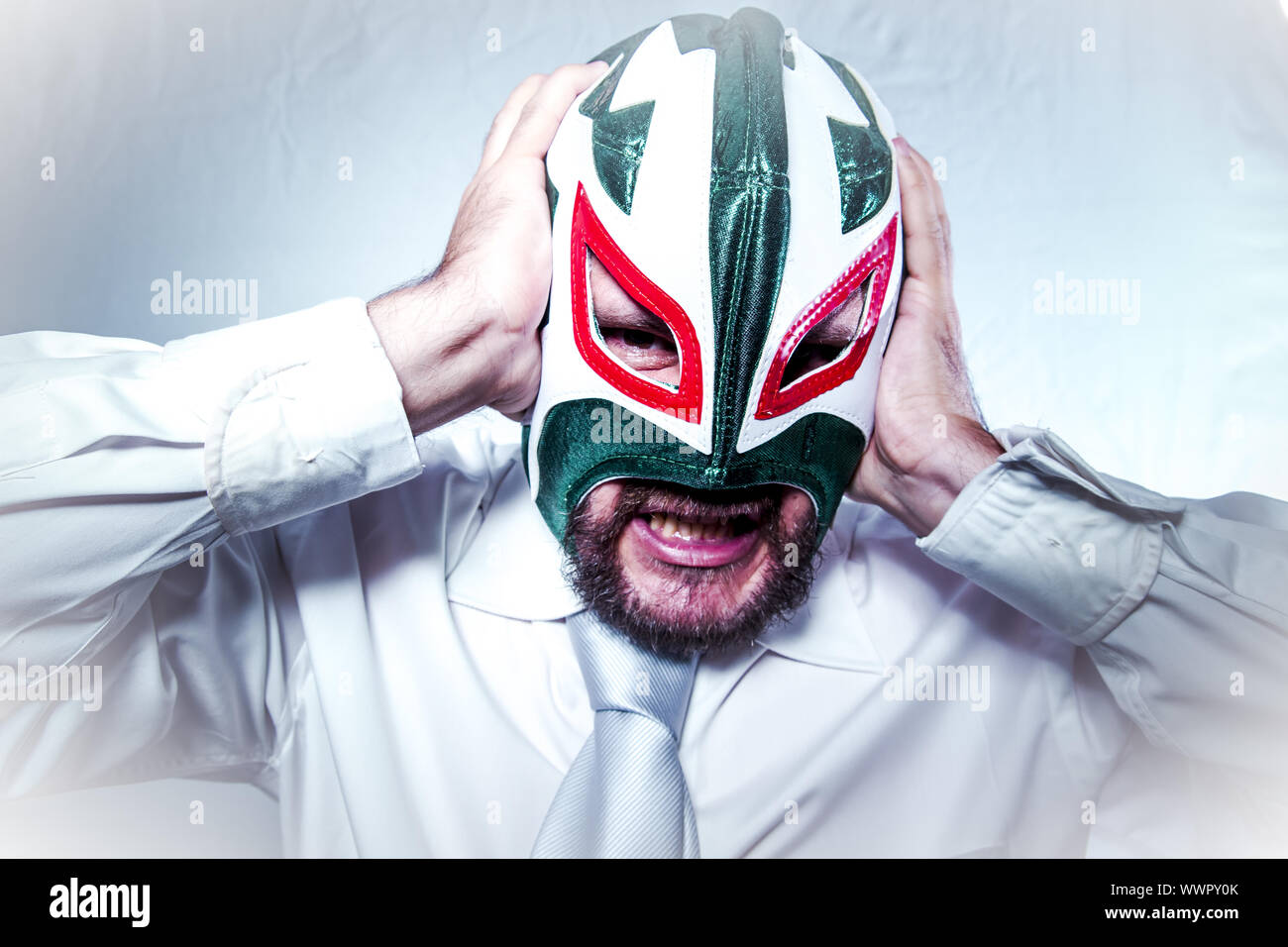 angry businessman with Mexican wrestler mask, expressions of anger and rage Stock Photo
