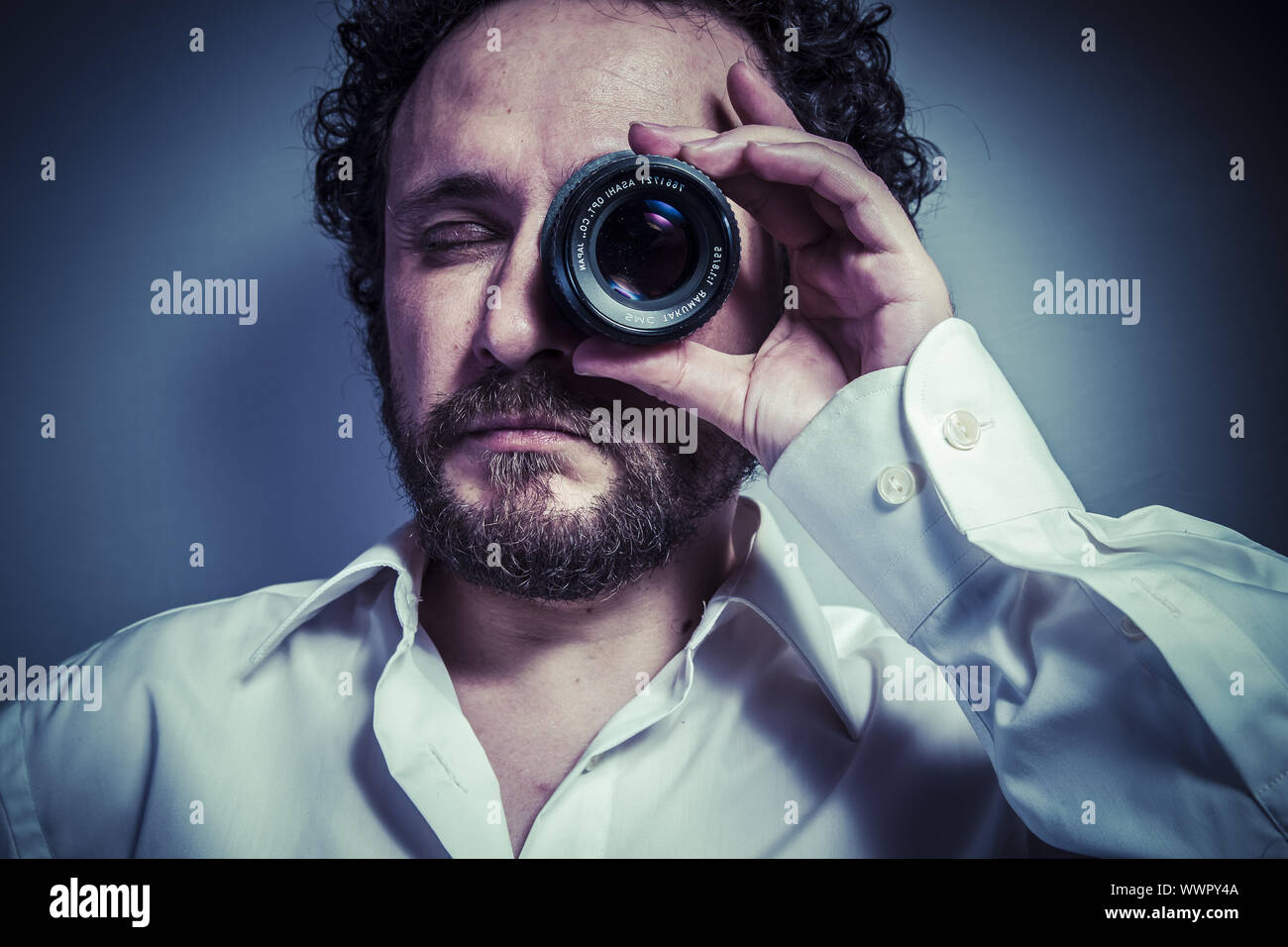 photographer with lens, man with intense expression, white shirt Stock