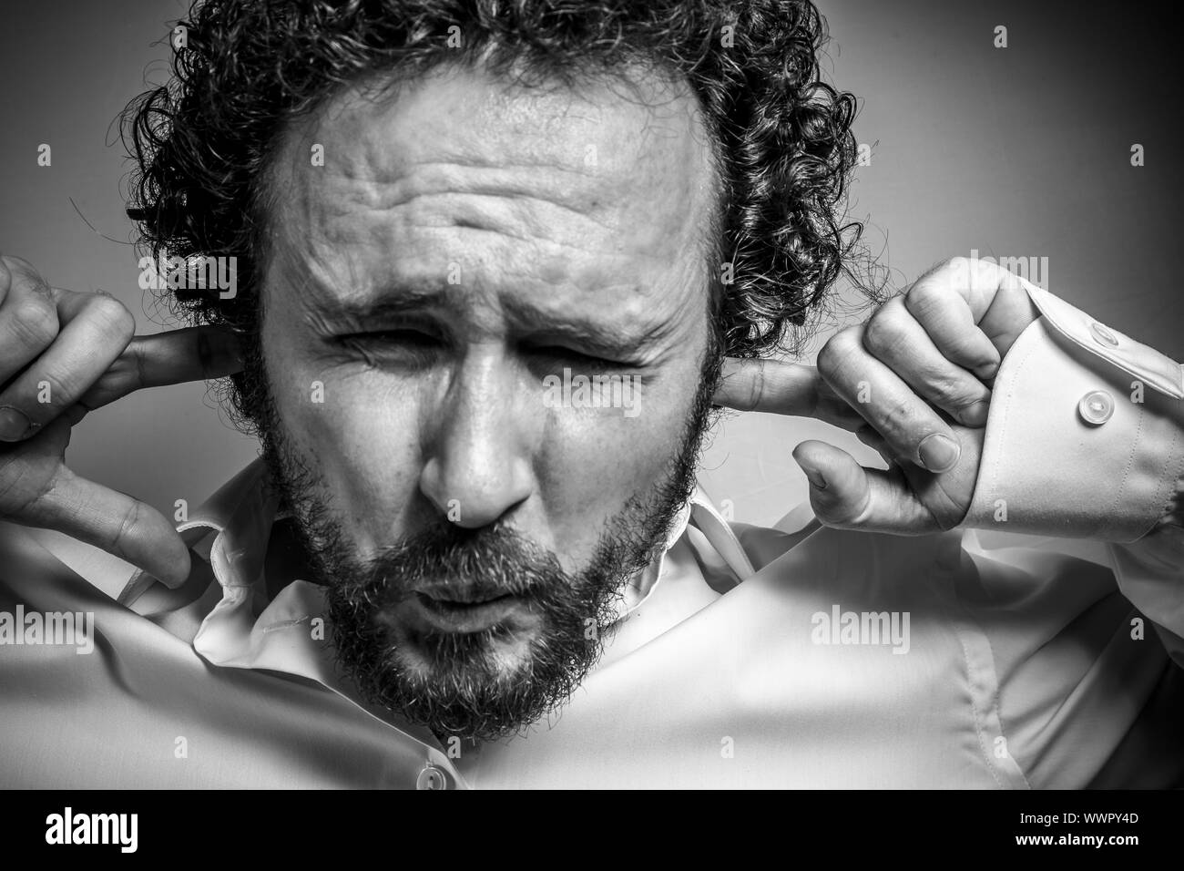 I do not want to hear anything, man with intense expression, white shirt Stock Photo