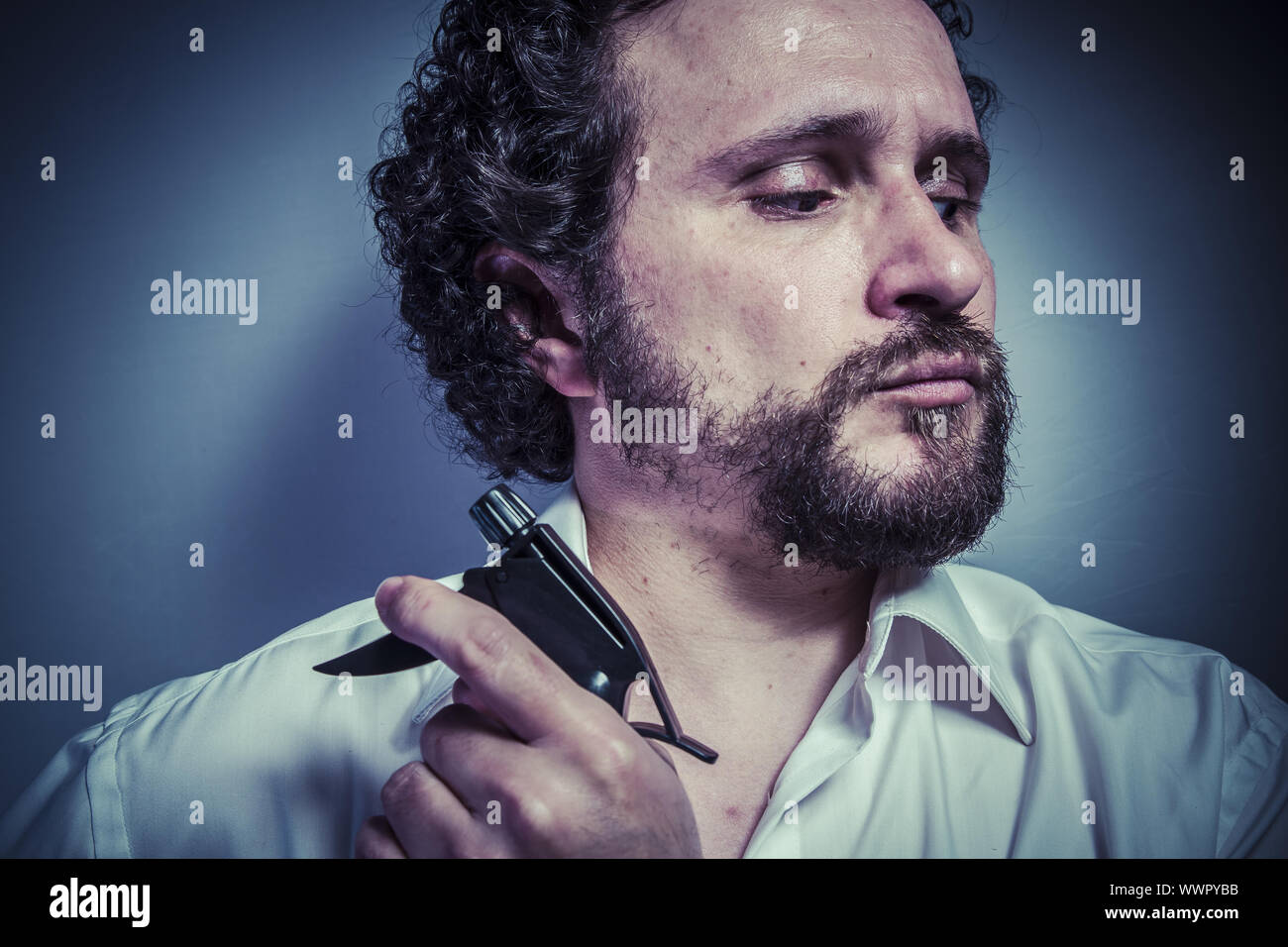 cleaning spray, man with intense expression, white shirt Stock Photo