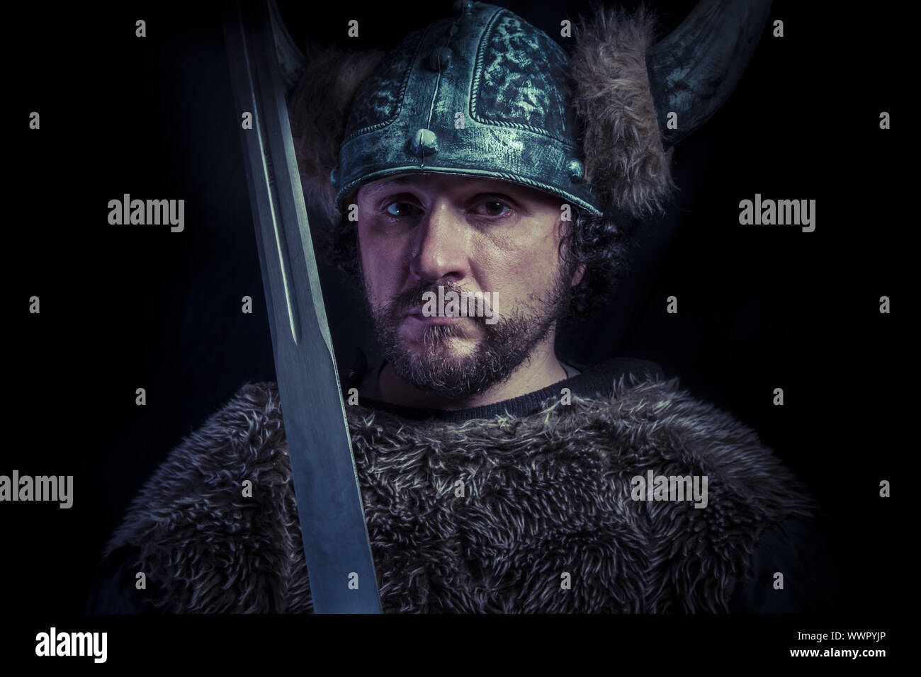 Costume, Viking warrior with a huge sword and helmet with horns Stock Photo Alamy