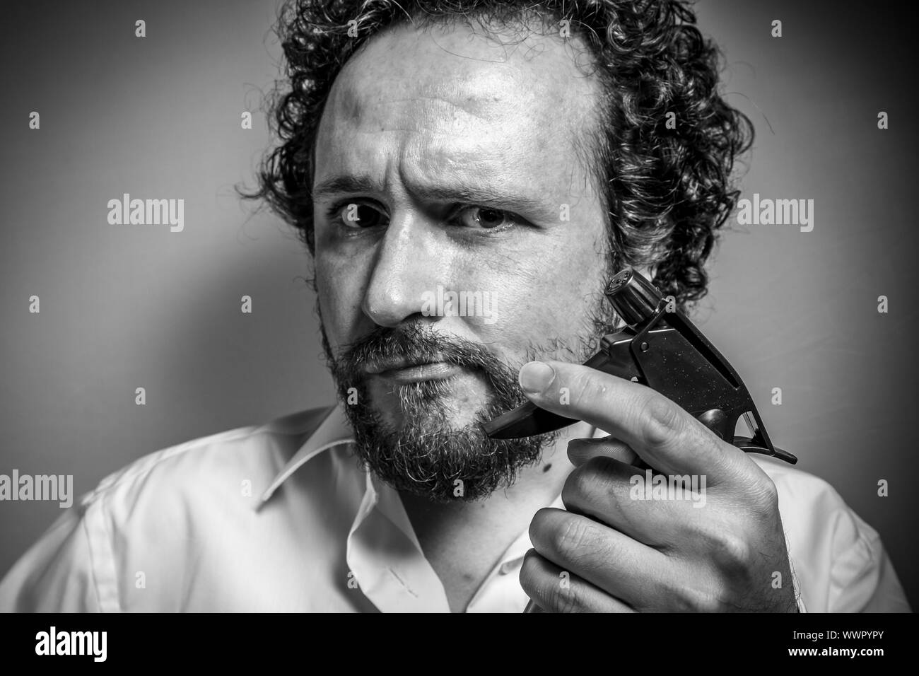 cleaning spray, man with intense expression, white shirt Stock Photo