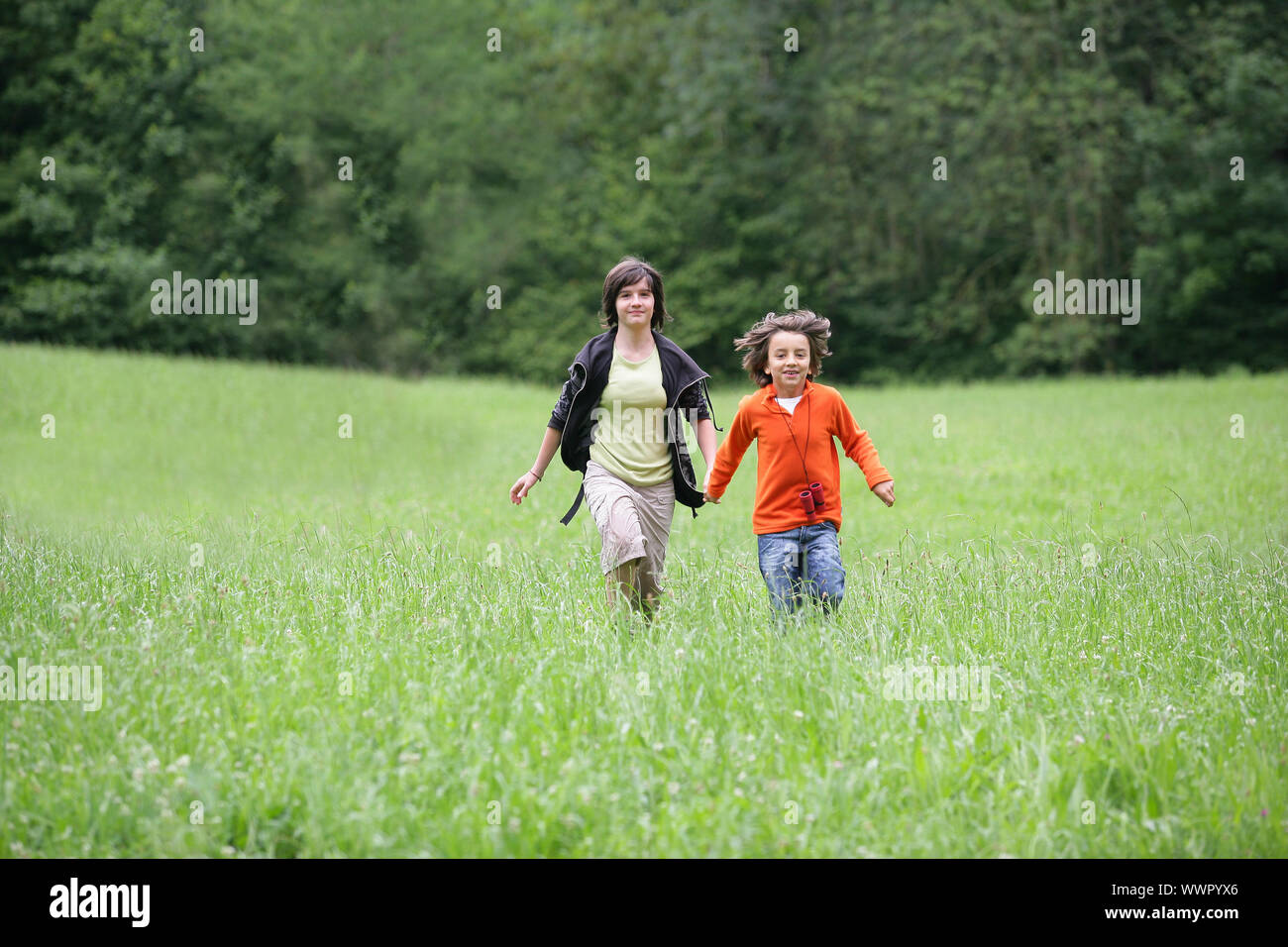 Brother and sister running hand-in-hand Stock Photo - Alamy