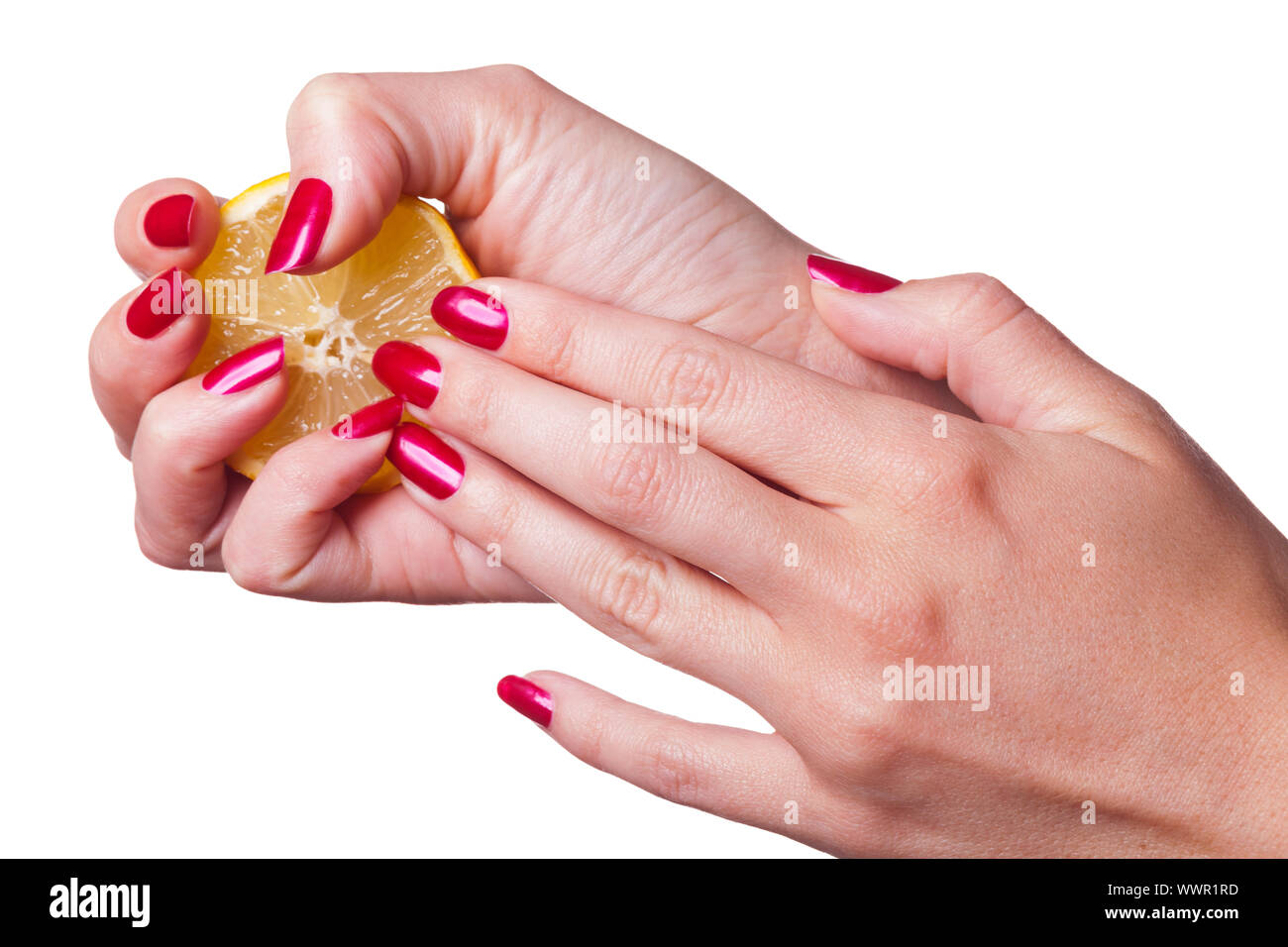 Hand with manicured nails squeeze lemon on white Stock Photo